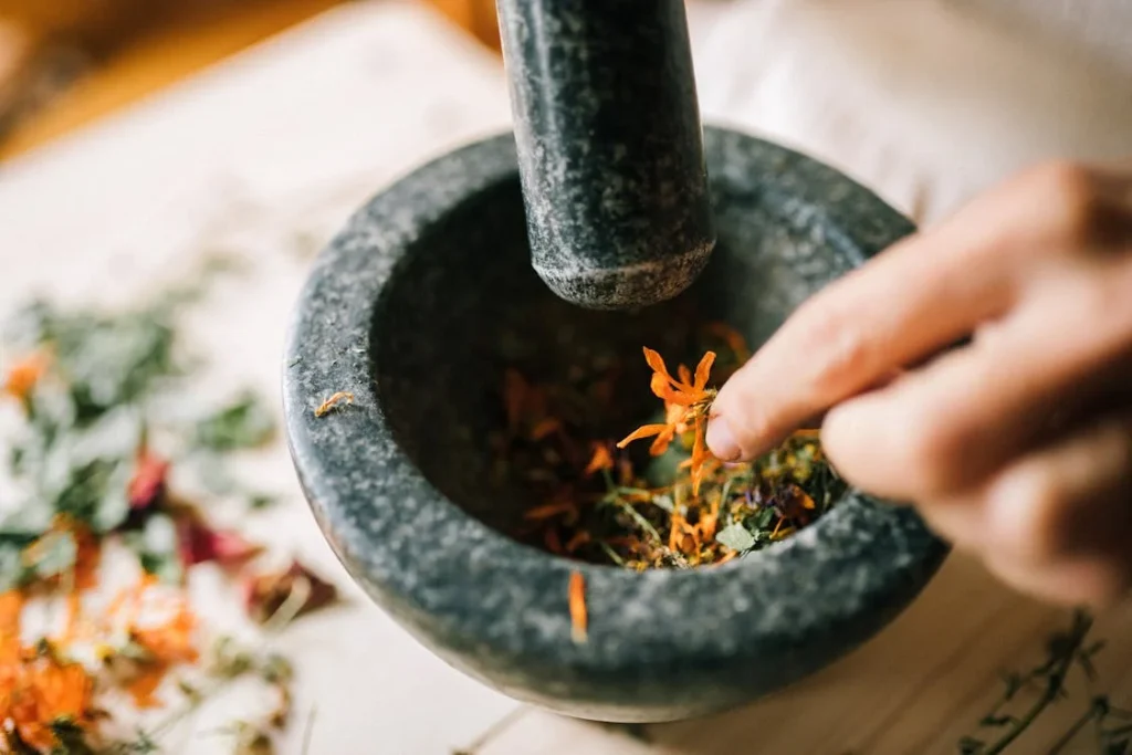 A hand mixing spices in a mortar and pestle - spice mix recipes