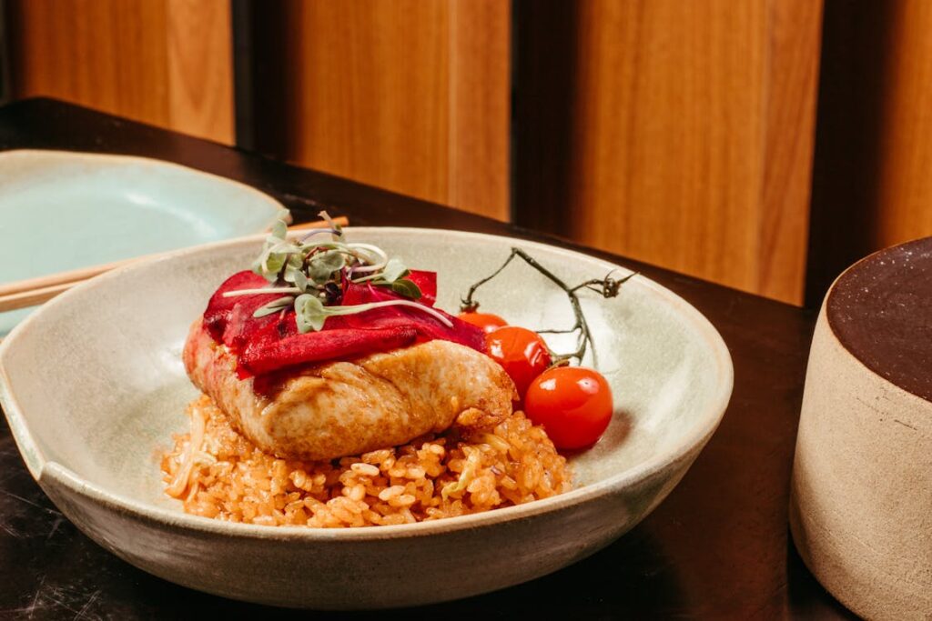 A plated dish with rice paired with curry or grilled meat