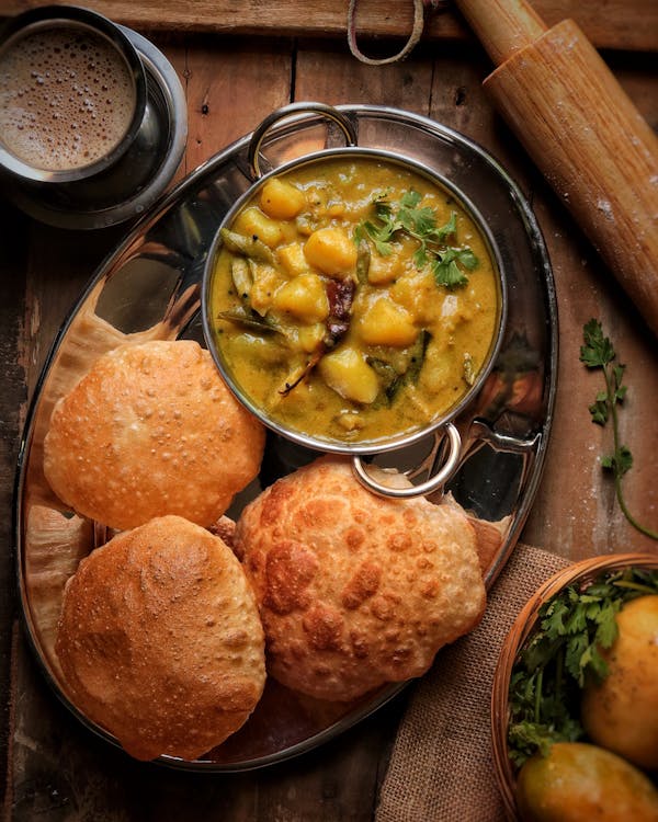 A traditional Indian thali platter featuring daal as a central dish along with rice chapati and side vegetable