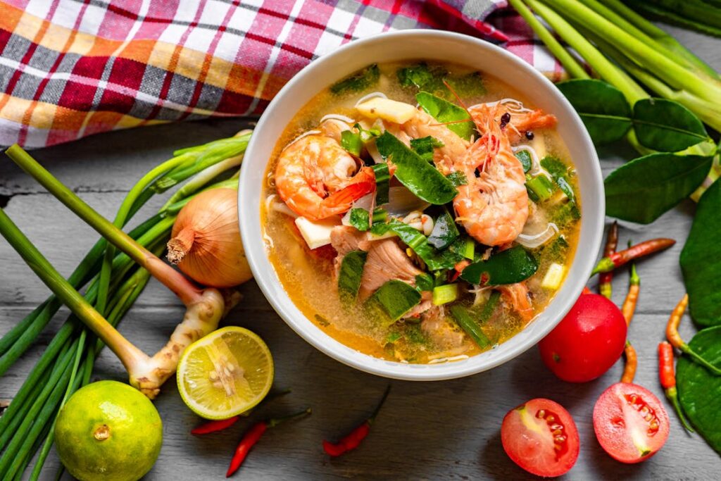 A vibrant bowl of mixed lentil soup garnished with fresh coriander and a squeeze of lemon