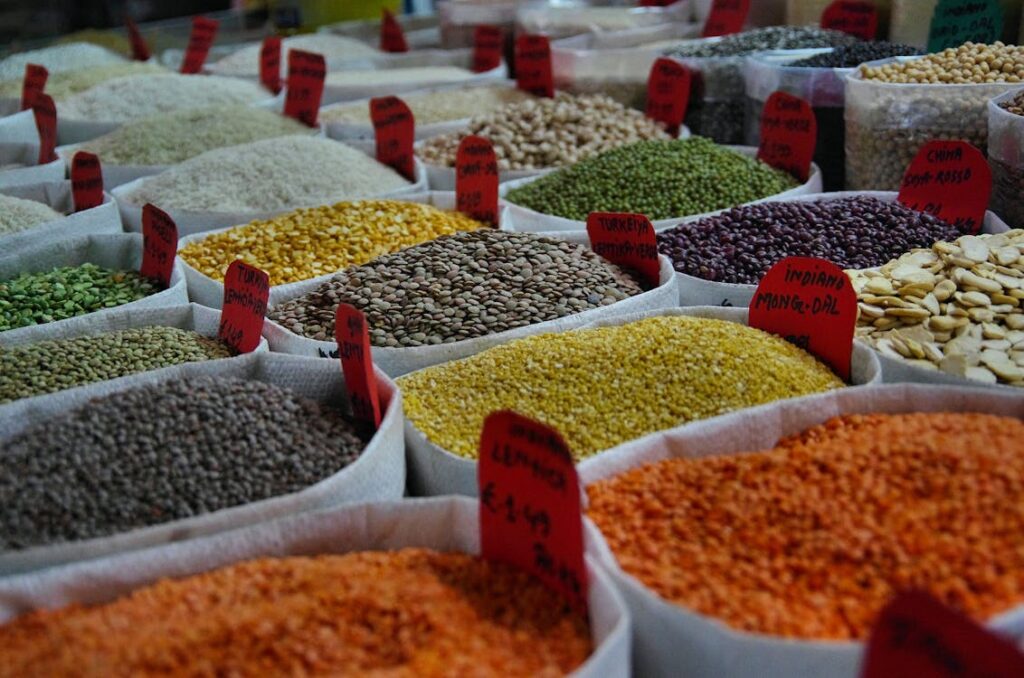 Close up of various uncooked lentils in bowls showcasing their variety red yellow green and brown lentils