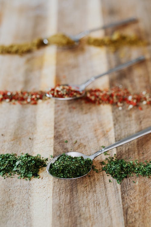 The various whole spices used in Achar Gosht Masala arranged on a wooden board