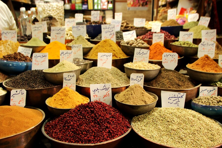 An image of a bustling Pakistani spice market with colorful heaps of spices capturing the cultural atmosphere